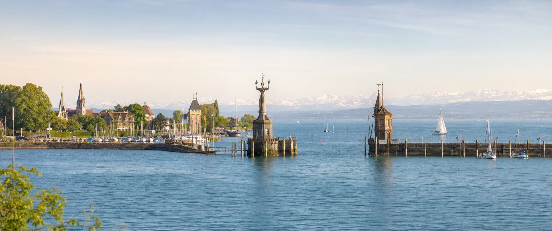 Blick auf den Konstanzer Hafen am Bodensee mit Imperia, Mole, Segelbooten und Alpenpanorama